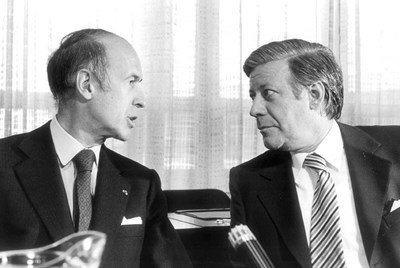 Vlevo na fotografii je Valéry Giscard d´Estaign a vpravo pak sedí Helmut Schmidt.