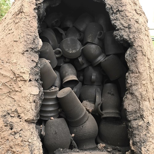 A kiln with smoke-fired pottery after opening.