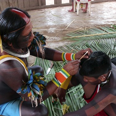 During festivals and parties, metoro, for these being effective in their social power, all the participants should achieve to be mei, beautiful, here a mebenghete covering the hairs of a young boy with rubber for these being fixed.