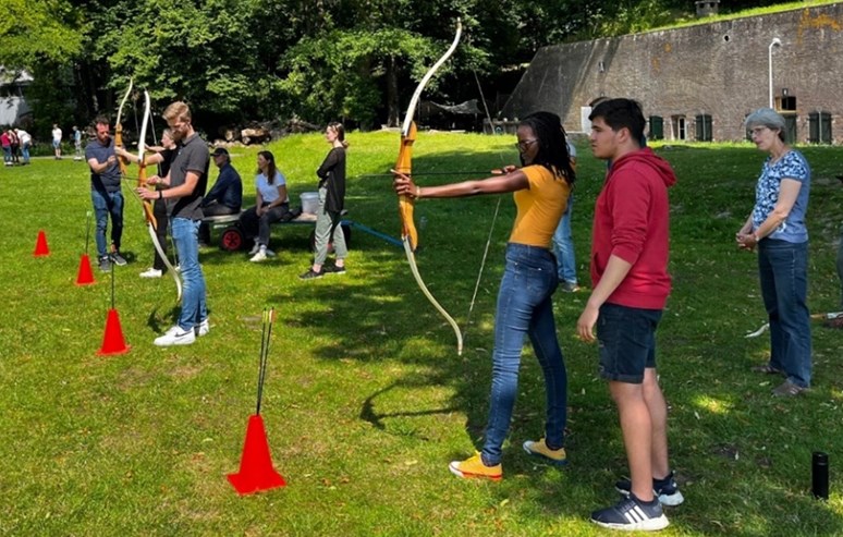 A picture of Susan about to shoot a bow and arrow (archery) during groups’ competition at the team-building event organized at Fort Vechten Utrecht